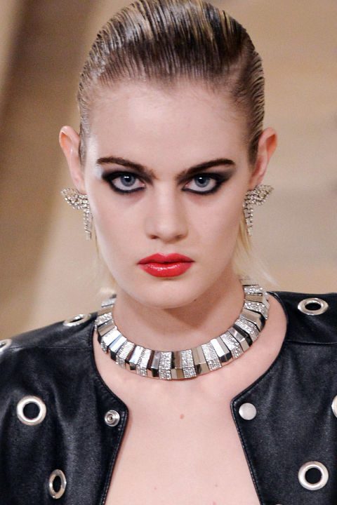 fully rimmed eyes with black eyeliner and red gloss lips