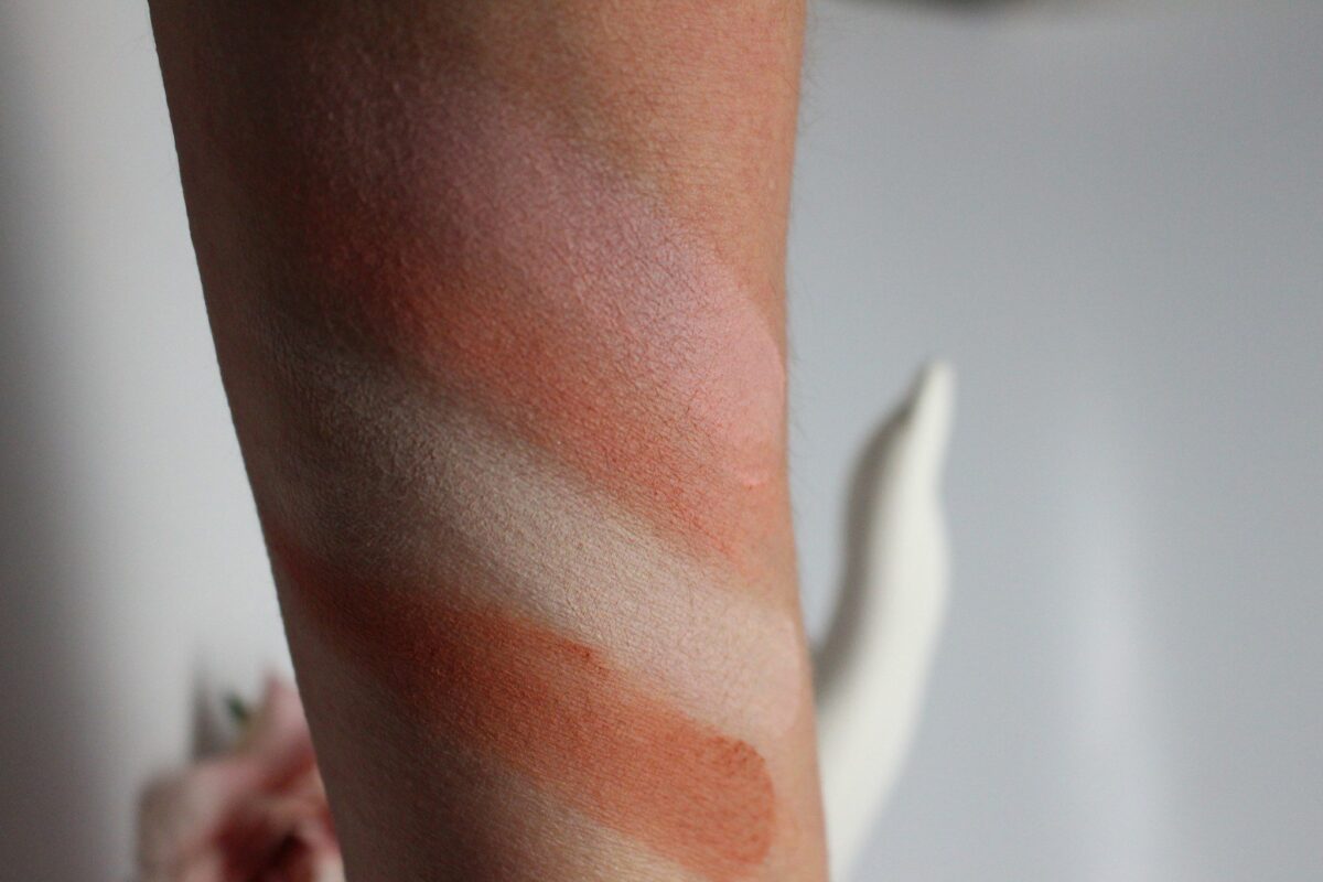 swatches of the four shades in the palette. The pink shade at the top and the peach shade underneath are eye shadows, or blush
