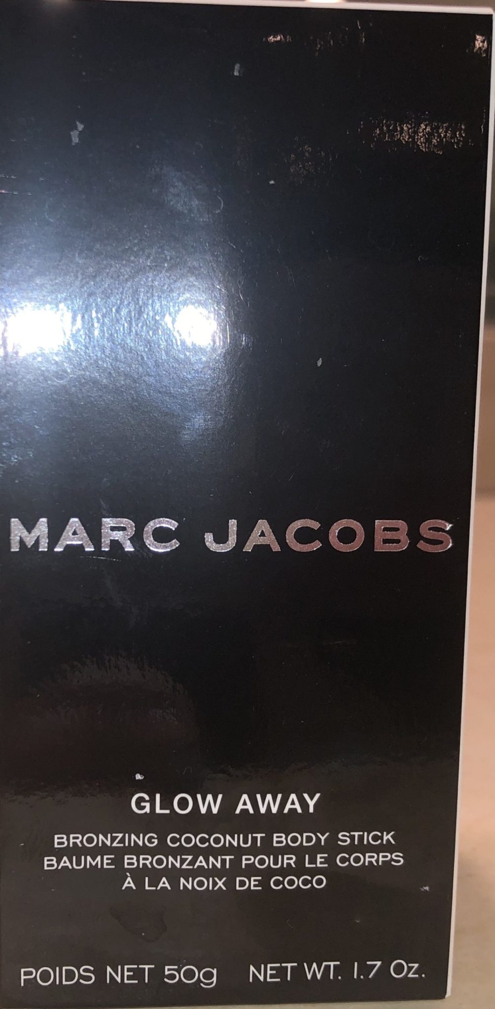 THE OUTER BOX FOR THE MARC JACOBS GLOW AWAY BRONZING COCONUT BODY STICK 