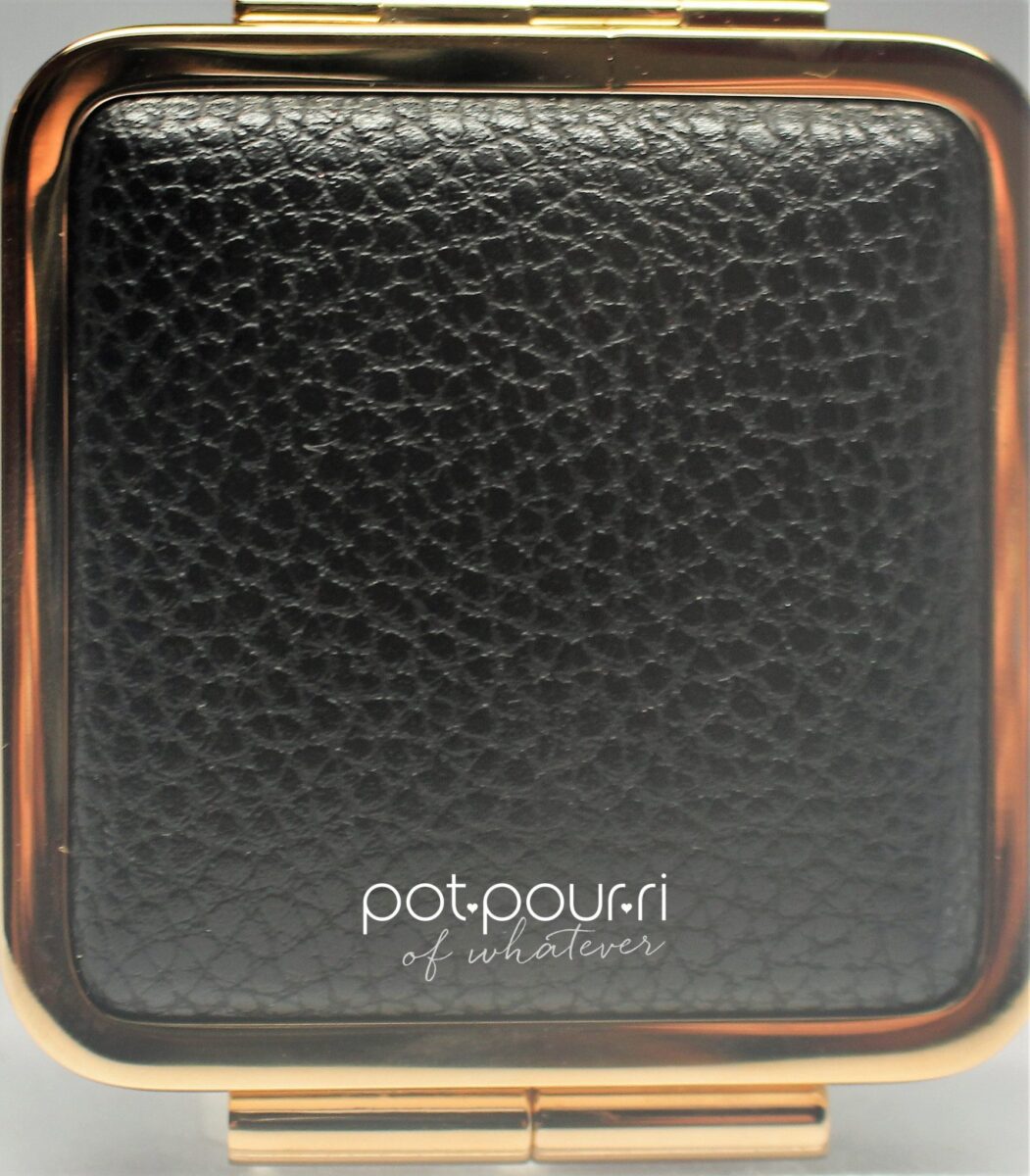 the cheek creme compact is leather-like with a pebbled texture and gold hardware