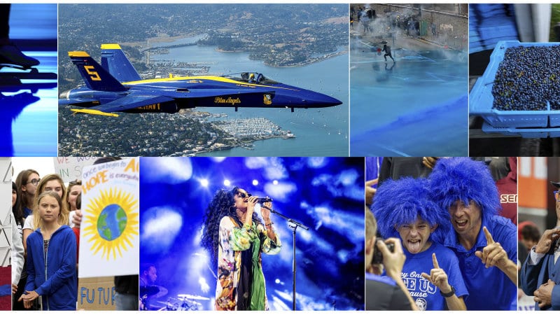 Skating Sprint in the Netherlands, on Feb. 23, 2019, U.S. Navy Blue Angel flying over Sausalito, Calif., on  Oct. 10, 2019, Police firing blue-colored water at protestors in Hong Kong on Aug. 31, 2019, a tray of wild blueberries at the Coastal Blueberry Service in Union, Maine on Aug. 24, 2018, bottom row from left, actress-writer Tina Fey wearing a blue gown at the Oscars on Feb. 24, 2019, Swedish youth climate activist Greta Thunberg, wearing a blue sweatshirt, during a protest outside the White House in Washington on Sept. 13, 2019, H.E.R. performing under blue lights at the Coachella Music & Arts Festival in Indio, Calif. on April 14, 2019, Duke fans wearing blue wigs before an NCAA college basketball game against Florida State in Tallahassee, Fla., on Jan. 12, 2019 and "Today" show co-host Al Roker wearing blue eye glasses on the set in New York on April 5, 201