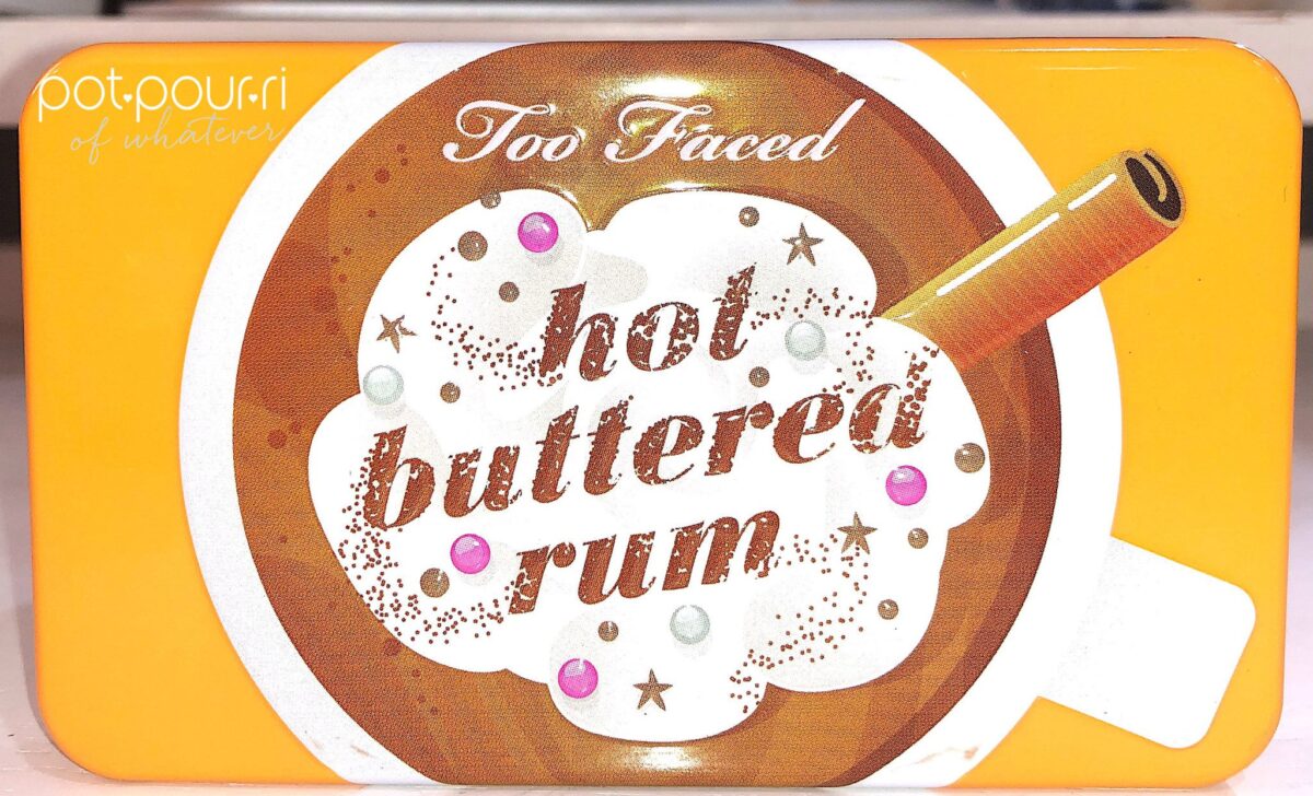 THE HOT BUTTERED RUM MINI PALETTE COMPACT WITH RAISED DESIGN ON THE FRONT OF THE METAL CASE